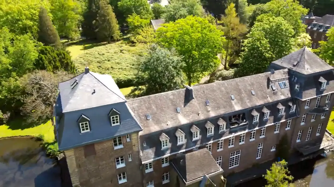 Der langgestreckte Schlossflügel mit Schieferdach aus der Luft