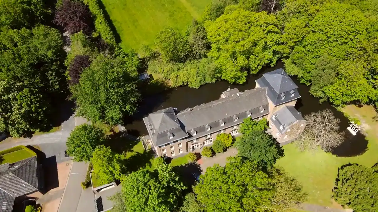 Luftaufnahme des Schlossparks mit altem Baumbestand und Wassergraben